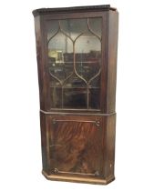 A Georgian mahogany corner cabinet, the dentil moulded cornice above an astragal glazed door