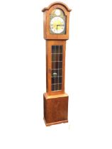 A German teak grandmother clock, the arched hood and arched dial with steel roman chapter ring