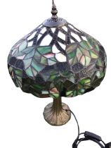 A Tiffany style faux bronze tablelamp with leaf cast column supporting bowl shaped leaded glass
