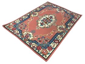 A machine woven Aubusson style rug, the pink field with central floral medallion and conforming