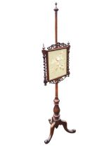 A Victorian mahogany foral needlework pole screen with fretwork crest and apron flanked by