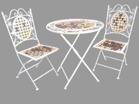 A circular painted folding garden table with two matching chairs, the woven latticework top and