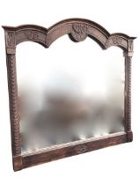 A C19th French régence style oak overmantel mirror, the triple arched cornice carved with shell,