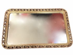 A rectangular mirror in pierced scrolled gilded frame with ropetwist border, the plate bevelled. (