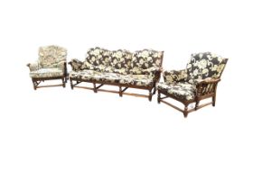 An Ercol oak three-piece suite, the three-seater sofa and armchairs with loose cushions, the spindle