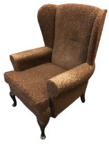 A Georgian style upholstered wing armchair, the arched back with curved wings above a rectangular