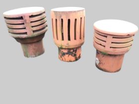 Three terracotta chimney cowls, with cylindrical pierced galleries above narrow tubular stems. (3)