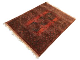 A Bokhara wool rug, the red field with three gul medallions within multiple geometric borders. (40.