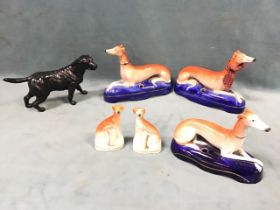 A pair of Victorian Staffordshire recumbent greyhounds; another similar dog inkwell; a pair of