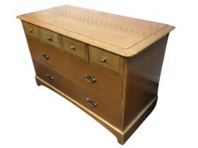 A pale mahogany Stag chest of drawers, the rectangular moulded top above three short and two long