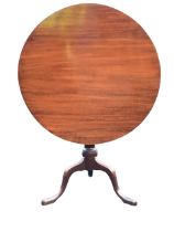 A Georgian mahogany circular tea table, the top tilting on a turned column, raised on a tripod