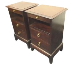A pair of mahogany Stag bedside cabinets, the moulded rectangular tops with pull-out brass knobbed