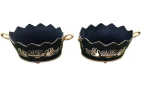 A pair of oval regency style baskets with scalloped rims and swan-neck handles, handpainted with