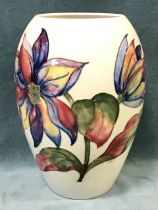 A Moorcroft tube-lined ovoid vase, decorated with flowers and leaves on white ground - signed and