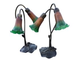 A pair of art nouveau style faux bronze tablelamps, each with tulip shaped glass shades on
