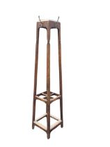 An Edwardian oak coatstand of square tapering form mounted with brass hooks above a four division