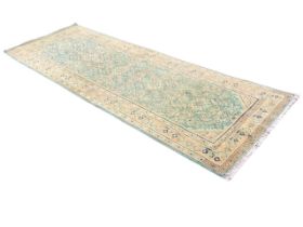 An Oushak runner, the green field with allover stylised flower and foliage motifs within a