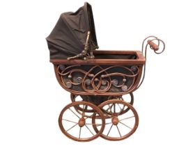 A toy pram with concertina hood above body with cane trelliswork sides, supported on a sprung