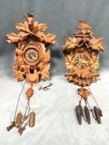 A boxwood chalet shaped cuckoo clock, carved with a fox and the crow amidst vine leaves and grapes