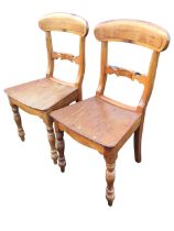 A pair of Victorian beech chairs, the rounded tablet backs above shaped joining rails and solid