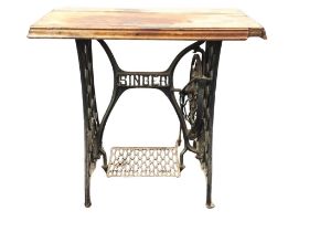 A mahogany and cast iron table, the rectangular moulded top above a base converted from a Singer