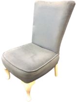 An upholstered bedroom chair, the flared rectangular back above a rounded square seat, raised on