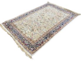 An oriental style rug, the ivory field woven with multifloral linked foliage with birds and animals,