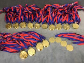 144 unused gilt metal swimming medals, the circular 2in medallions on red & blue ribbons. (144)