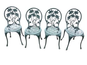 A set of four cast metal garden chairs, the hooped backs with pierced lily motifs above conforming