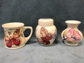 A Moorcroft vase with budding flowers on white ground, stamped & numbered; a Moorcroft mug,