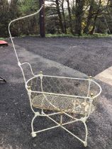 A Victorian wrought iron and brass cot, the oval brass chain basket with support for a canopy having