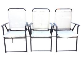 A set of three folding garden armchairs with fabric backs & seats, the platform arms on tubular