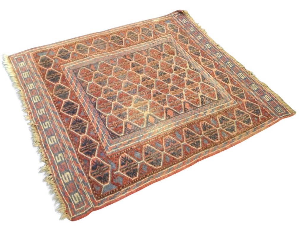 A Kurdish wool rug, the polychrome lozenge lattice field within geometric and conforming borders. (