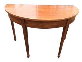 A C19th mahogany demi-lune hall table, the top above a plain apron, raised on tapering square legs