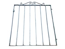 A wrought iron garden gate with rectangular spindle bars, having decorative scrolled crest rail. (