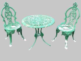 A Victorian style cast garden table and pair of chairs, the scrolling foliage circular pierced table