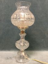 A cut crystal glass tablelamp, the fluted bulb-shaped shade above a baluster in the form of an oil