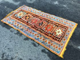 A Caucasian rug, the dark brown field with multicoloured rectangular star medallions, within lozenge