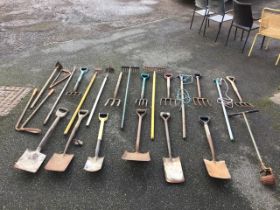 A quantity of garden tools - spades, forks, hoes, rakes, a telescopic lopper, a lawn edger, etc. (