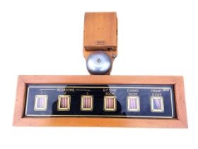 An Edwardian electric mahogany cased servants bellboard, the bell above an églomisé display with six