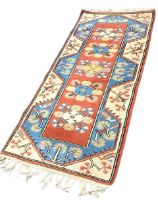 A Turkish Karapinar wool rug, the red field with five floral lozenge medallions within broad