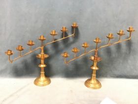 A pair of Victorian brass gothic candelabra, the angled arms with six sconces above scalloped drip