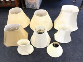 Seven cream silk lampshades - a conical pleated pair, octagonal,hexagonal, flared, and three