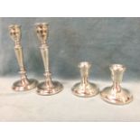 A pair of hallmarked silver candlesticks, with urns on tapering columns having turned knops, on