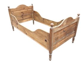 A continental pine sleigh bed, the shaped arched panelled head and footboard flanked by hexagonal