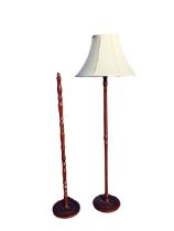 A stained hardwood standard lamp, the turned column on a circular base, with a fabric shade -