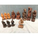 A set of three carved hardwood Chinese figurines; another later set of three in carved boxwood on