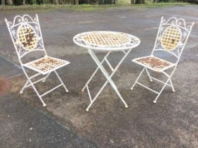 A circular folding garden table and two chairs, with woven latticework seats, backs and tabletop