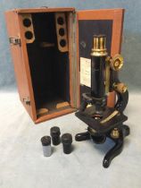 A cased Kima microscope by W Watson & Sons - London, with 0.66in & 0.33in optics and additional
