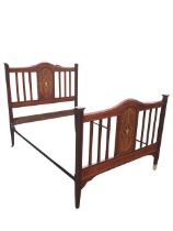 An Edwardian mahogany bed, the arched head and footboards with chequered stringing above staves